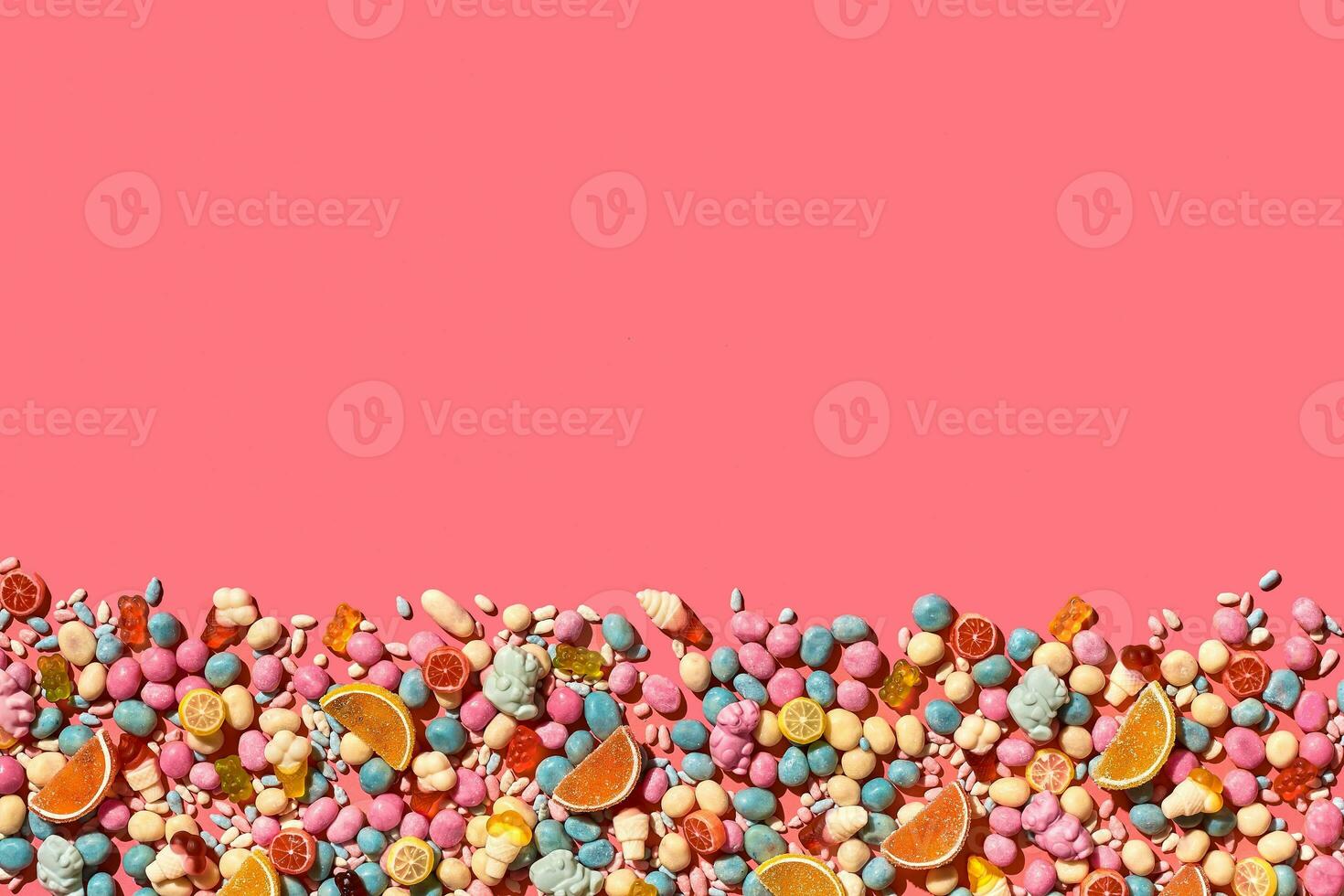 Various sweets, candys are palced on the photo on the coral background