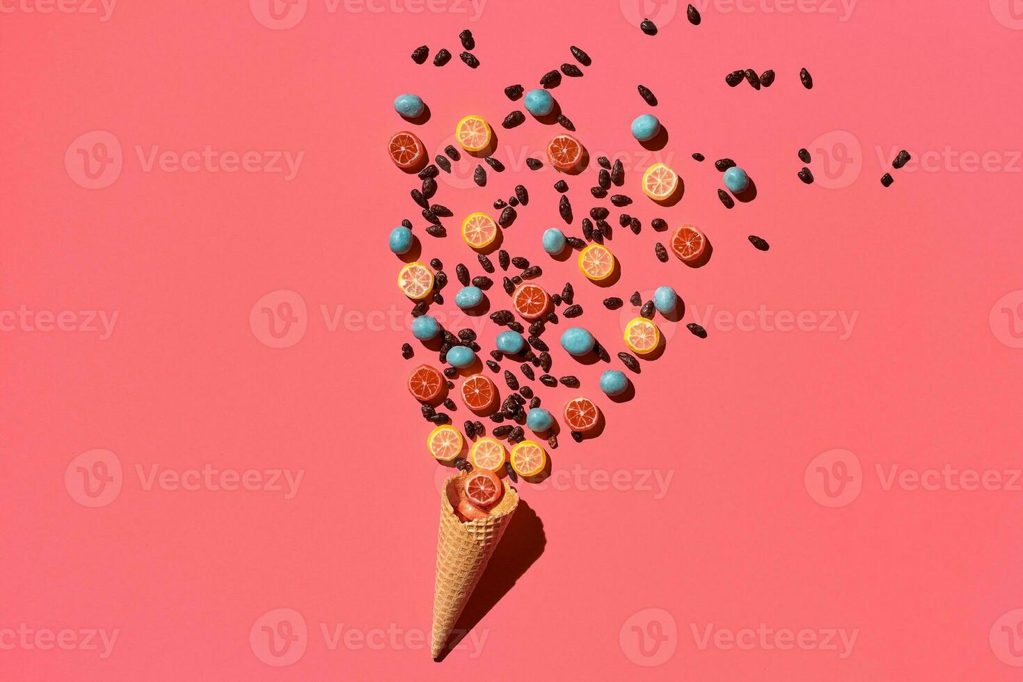 A variety of delicious sweets explode from the waffle cone, view from above. From left to the right direction photo