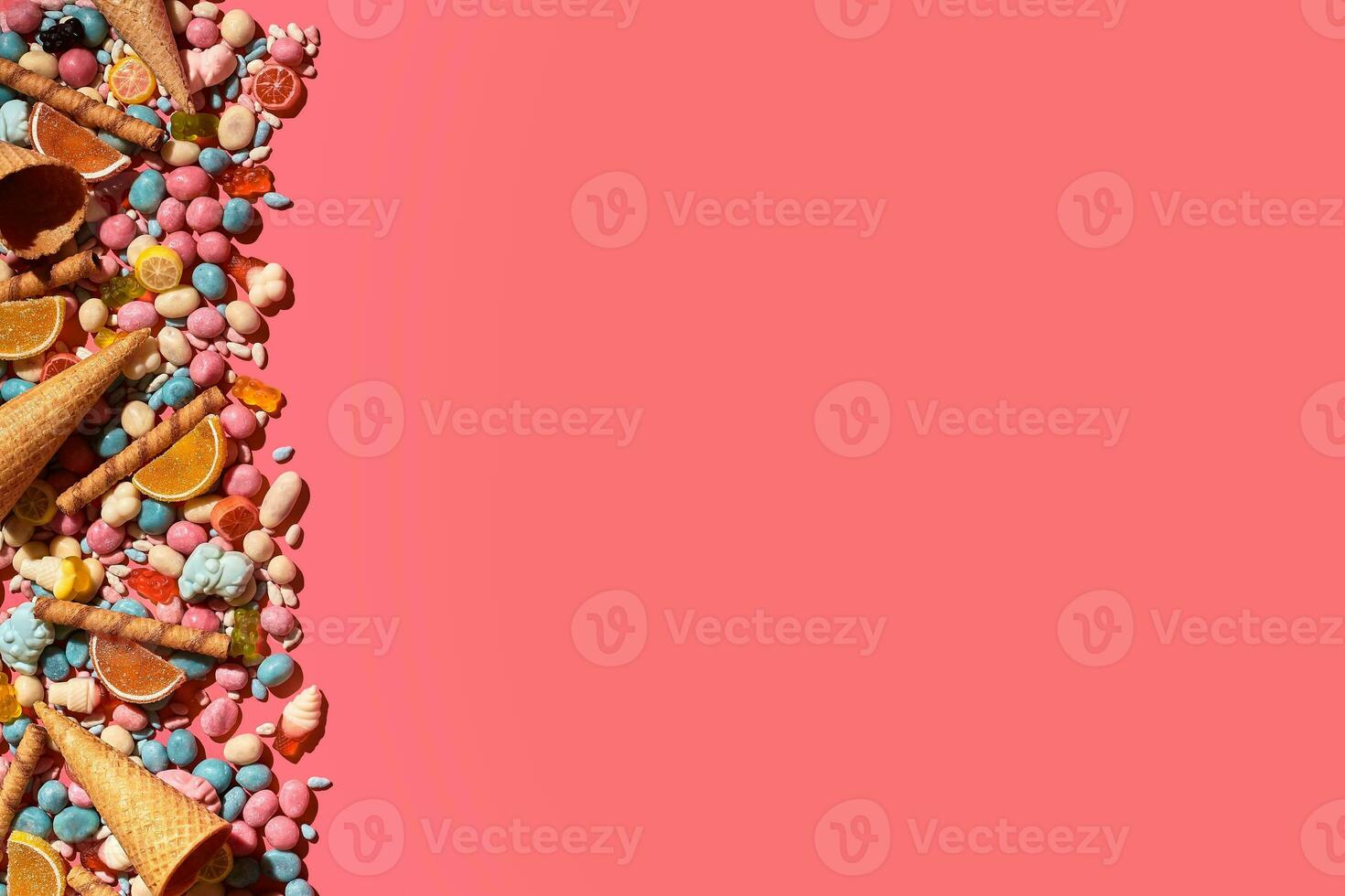 Various sweets, candys are palced on the photo on the coral background