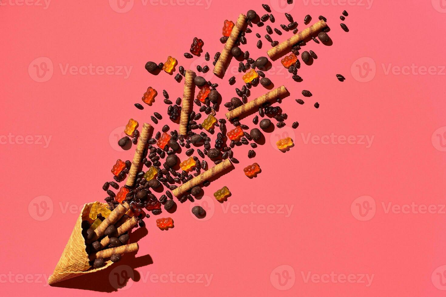 A variety of delicious sweets explode from the waffle cone, view from above. From left to the right direction photo