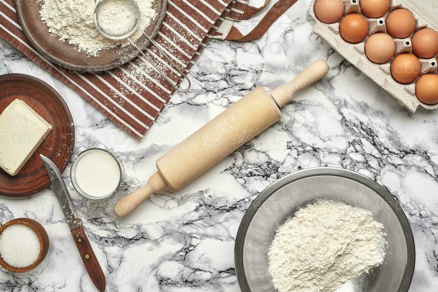 Close-up shot. Top view of a baking ingredients and kitchenware on the marble table background. photo