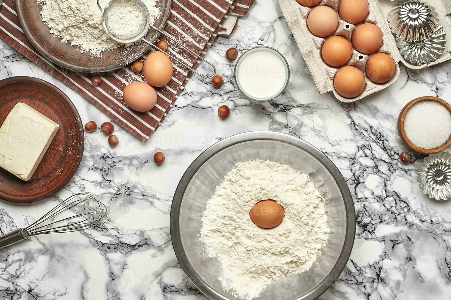 Close-up shot. Top view of a baking ingredients and kitchenware on the marble table background. photo