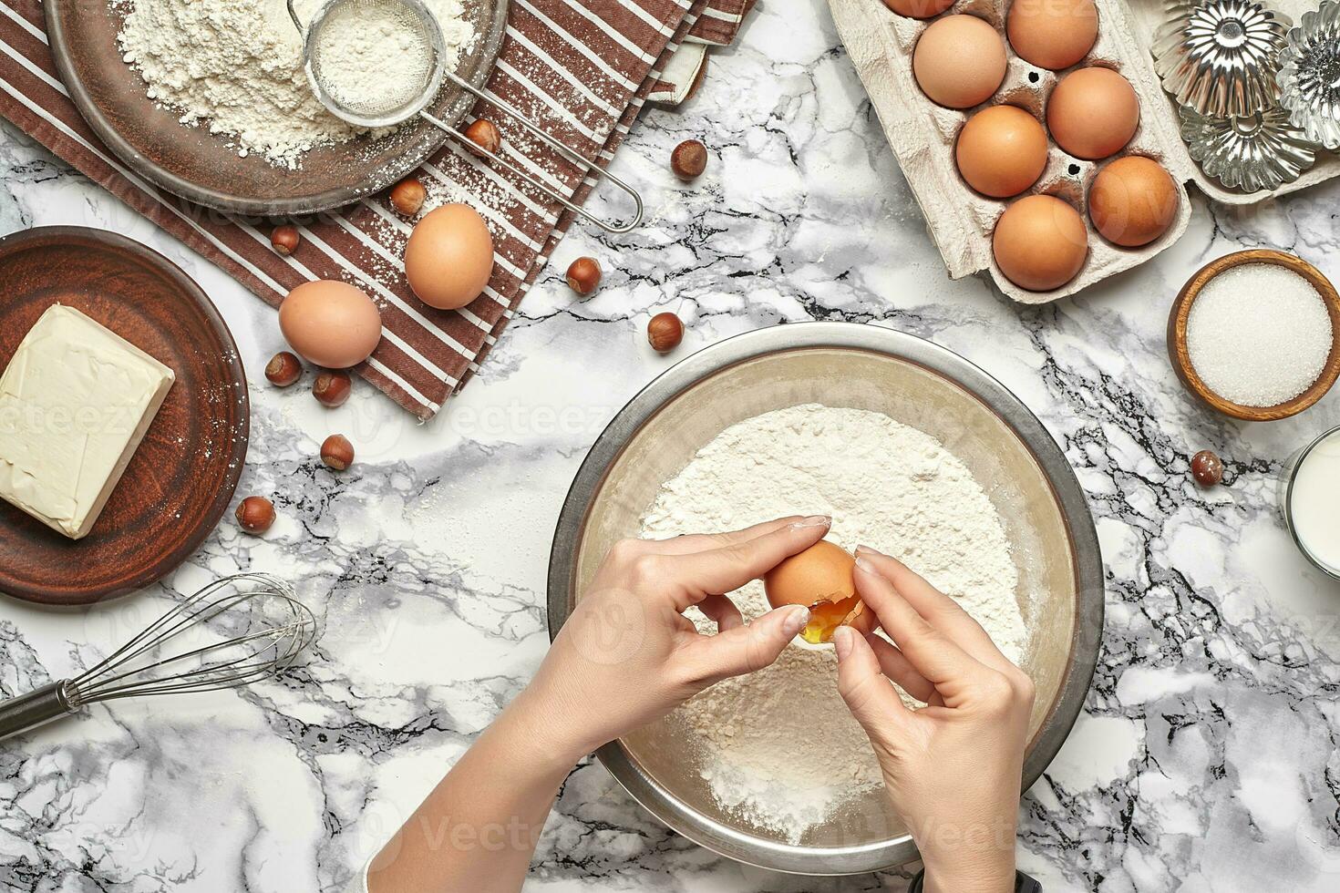 Close-up shot. Top view of a baker cook place, hands are working with a raw dough on the marble table background. photo