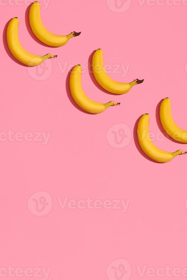 modelo composición de un par de bananas acostado siguiente a un rosado antecedentes , parte superior ver foto