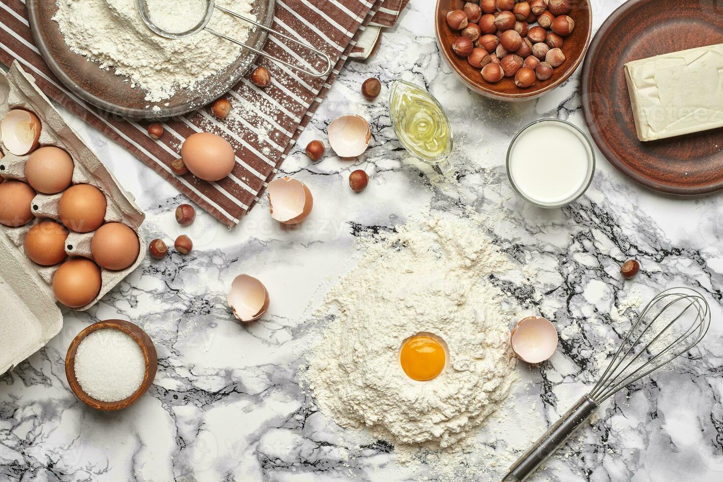 Close-up shot. Top view of a baking ingredients and kitchenware on the marble table background. photo