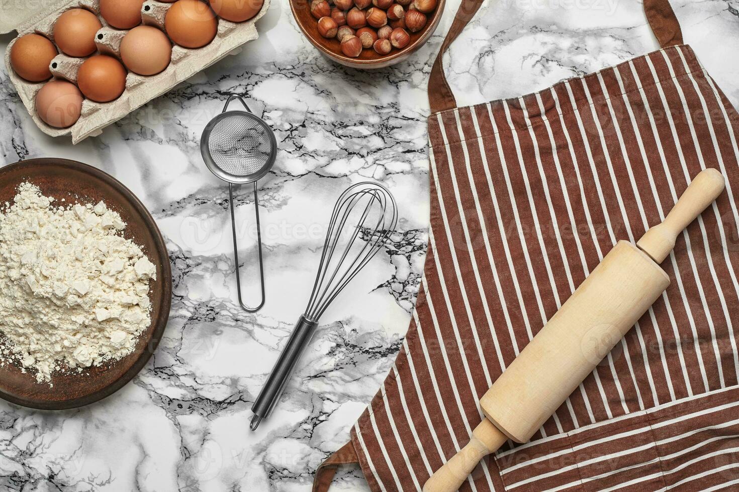 Close-up shot. Top view of a baking ingredients and kitchenware on the marble table background. photo