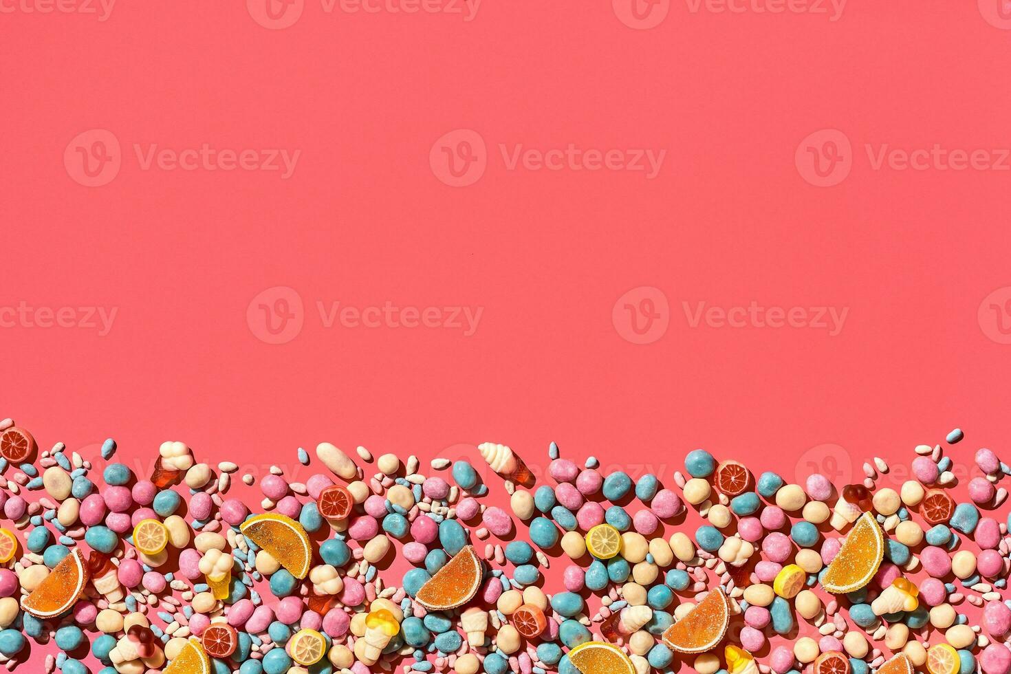 Various sweets, candys are palced on the photo on the coral background