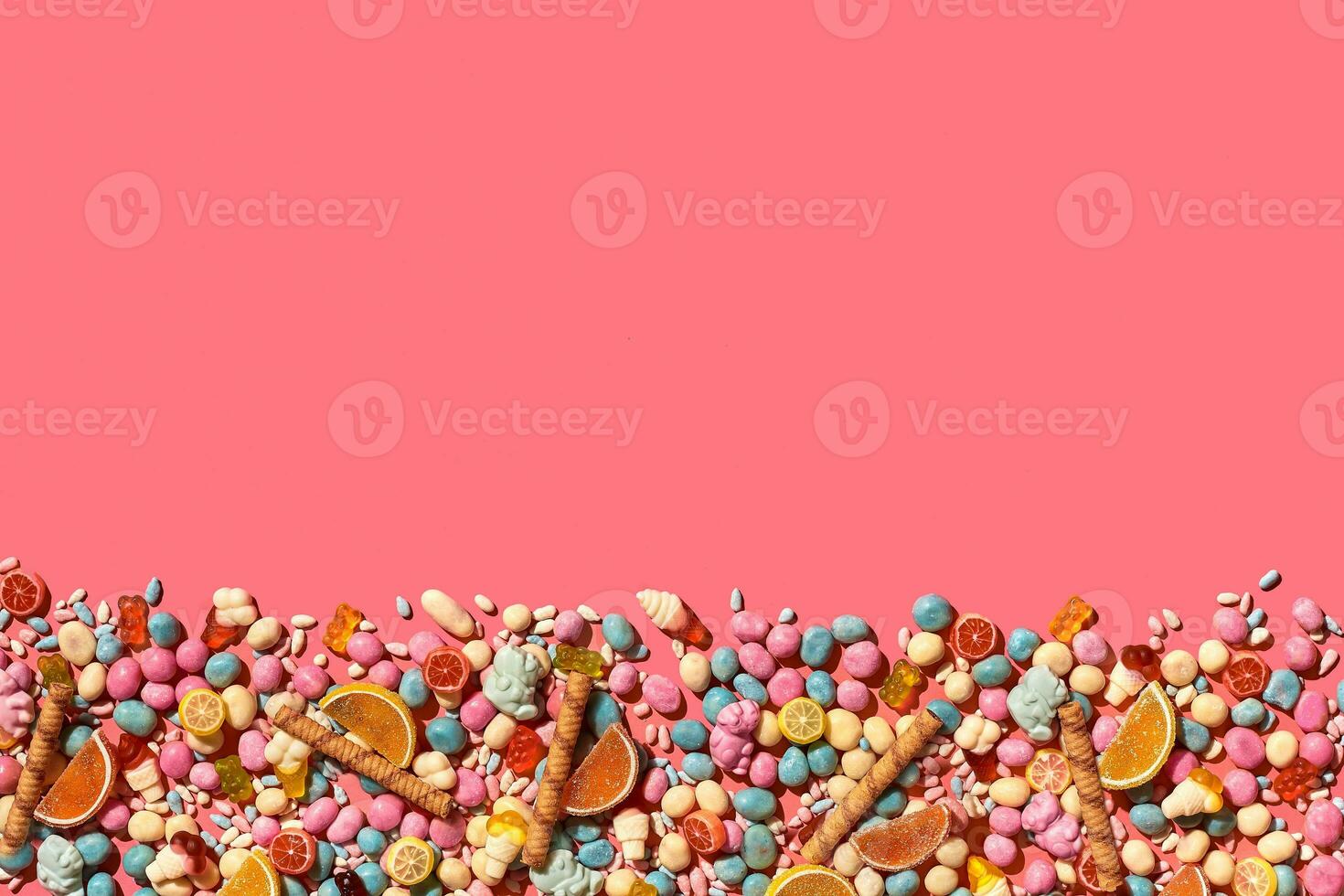 Various sweets, candys are palced on the photo on the coral background