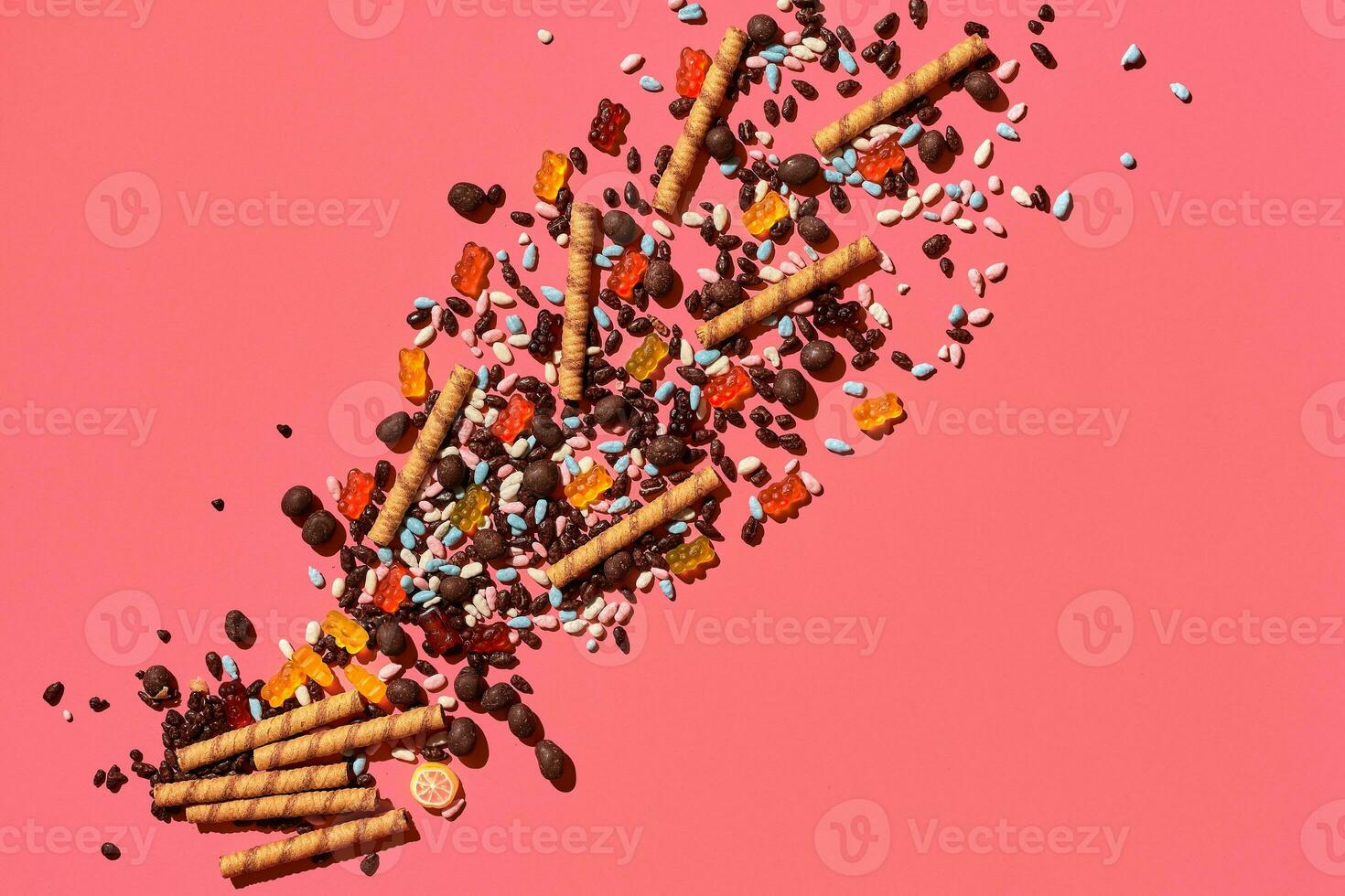 A heap of delicious sweets explode from the corner of image to the top, view from above. From left to the right direction photo