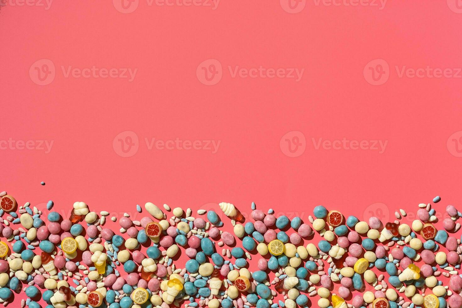 Various sweets, candys are palced on the photo on the coral background