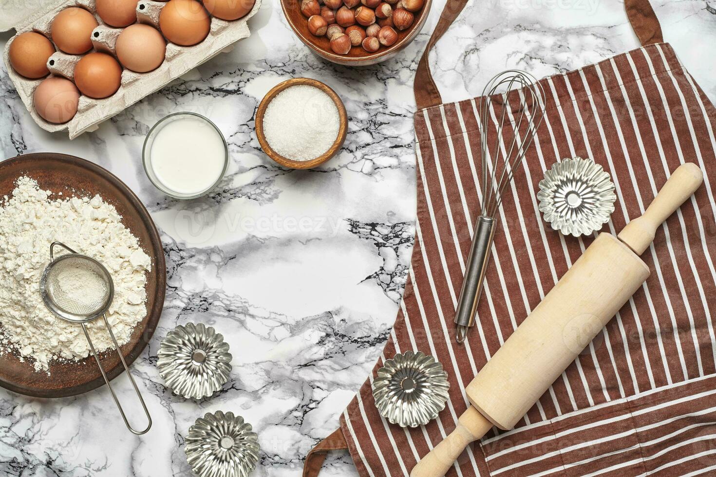 Close-up shot. Top view of a baking ingredients and kitchenware on the marble table background. photo