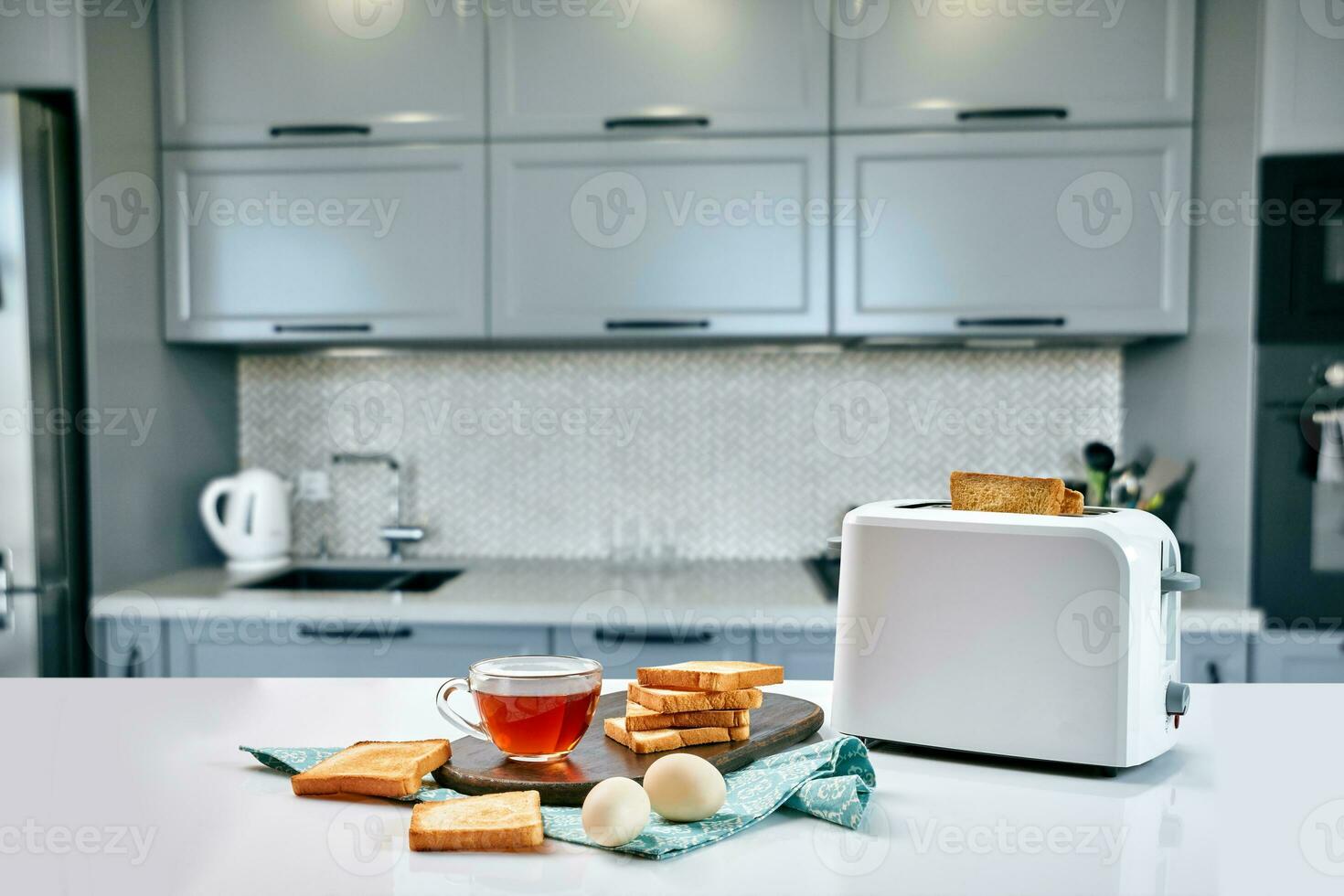 Breakfast in the cozy kitchen. Useful and tasty food. Tea and toast in a toaster, eggs. photo