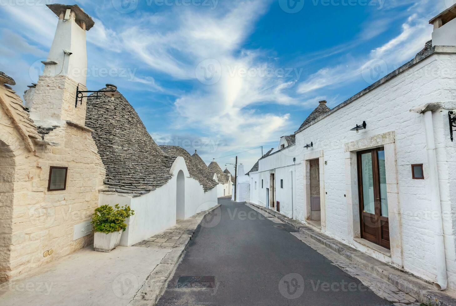 Beautiful town of Alberobello with Trulli houses among green plants and flowers, Apulia region, Southern Italy. photo