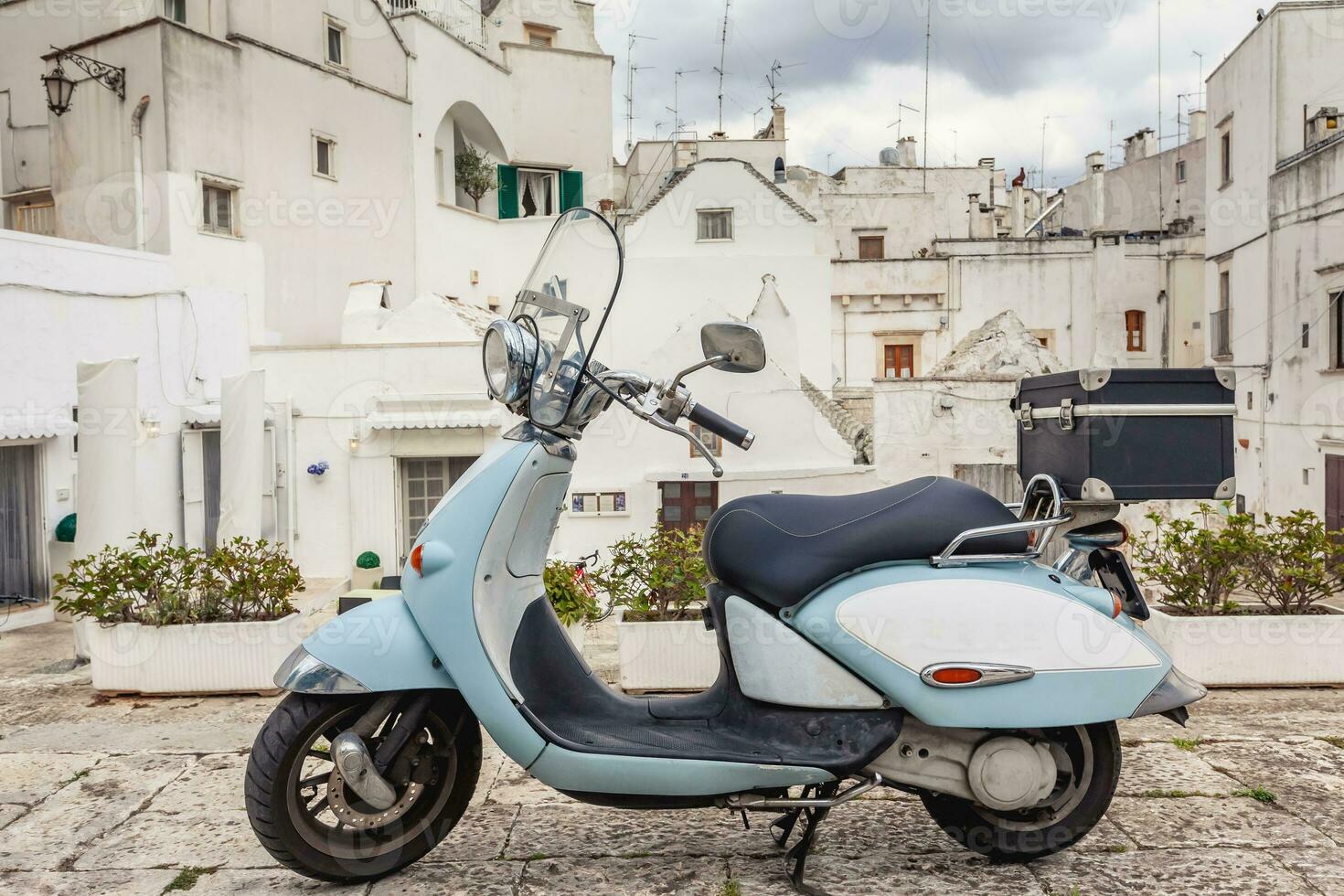 ver de el antiguo pueblo de martina franca. clásico azul ciclomotor en el antecedentes de un antiguo edificios foto