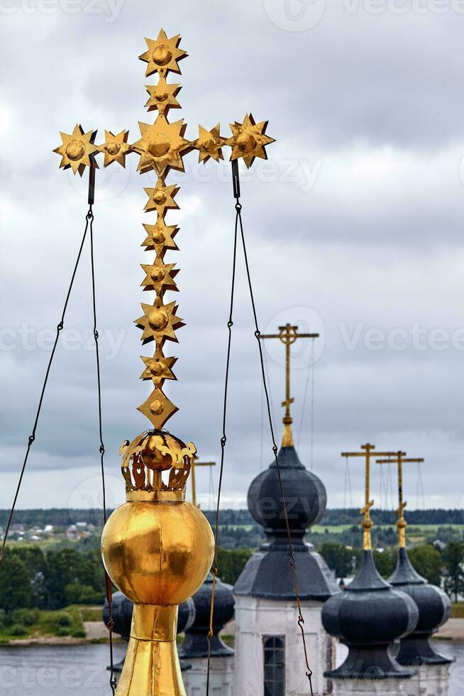 Eastern orthodox crosses on gold domes, cupolas, against blue sky with clouds photo