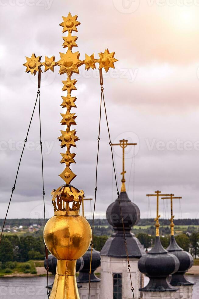 Eastern orthodox crosses on gold domes, cupolas, against blue sky with clouds photo