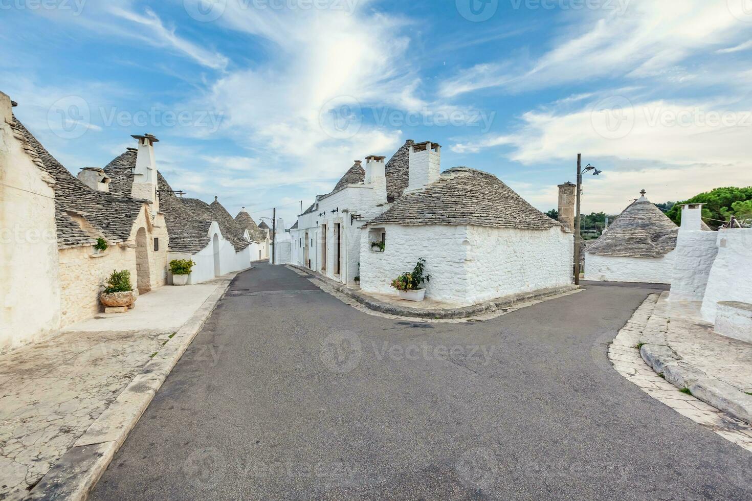 Beautiful town of Alberobello with Trulli houses among green plants and flowers, Apulia region, Southern Italy. photo