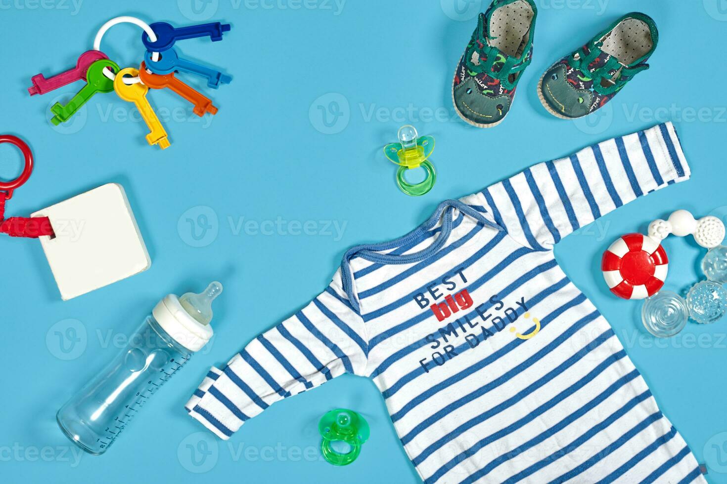 Baby clothing, toiletries, toys and health care accessories on blue background. photo