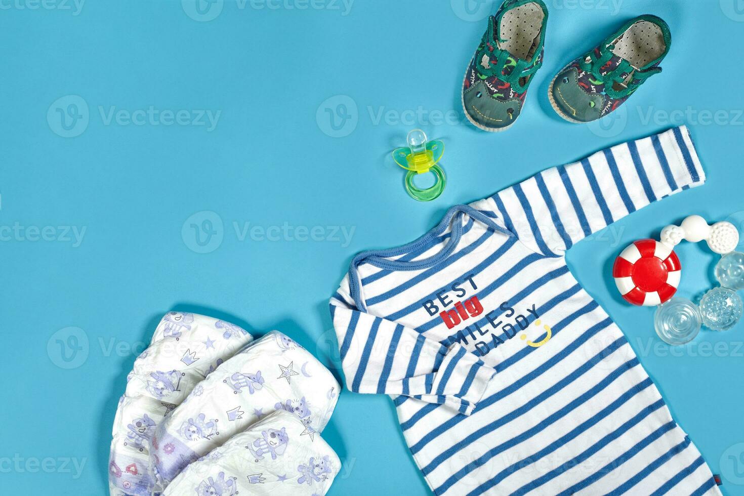 Baby clothing, toiletries, toys and health care accessories on blue background. photo