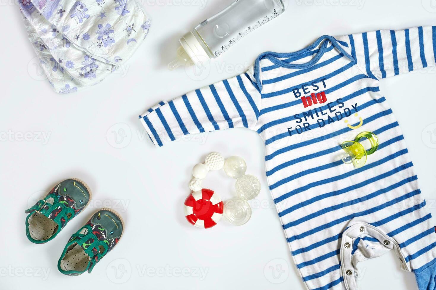 Baby care accessories and clothing on white background, top view photo