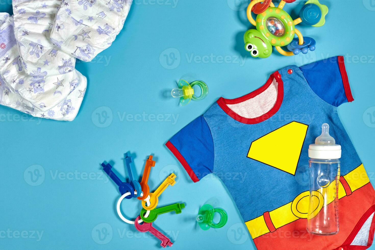 Baby clothing, toiletries, toys and health care accessories on blue background. photo