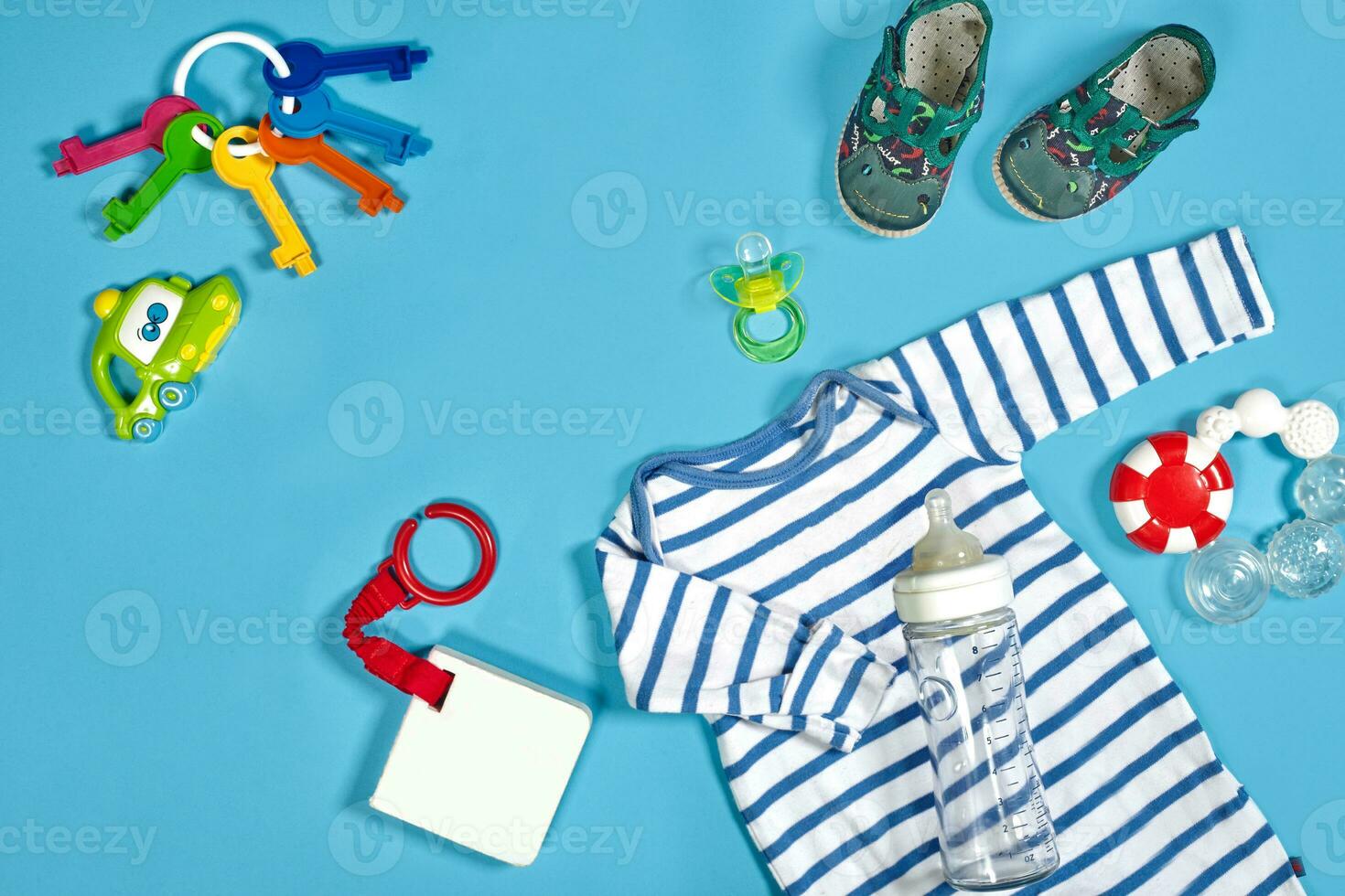 Baby clothing, toiletries, toys and health care accessories on blue background. photo