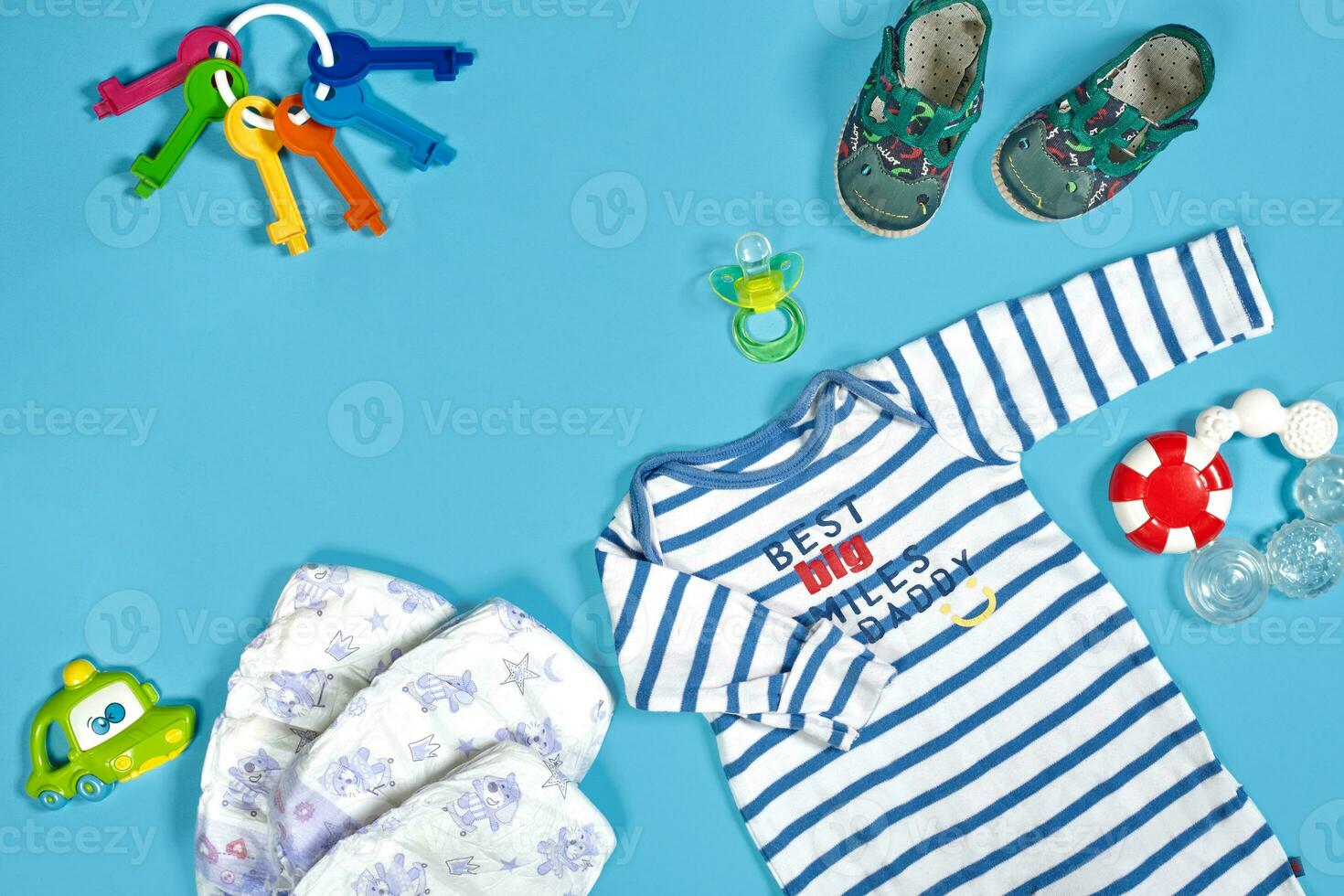 Baby clothing, toiletries, toys and health care accessories on blue background. photo