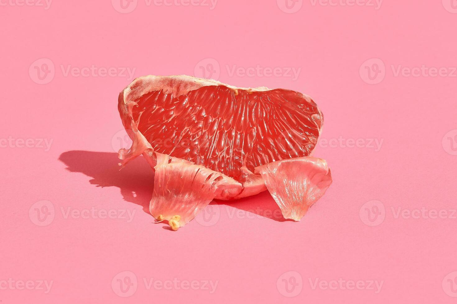 Half of grapefruit citrus fruit isolated on pink photo