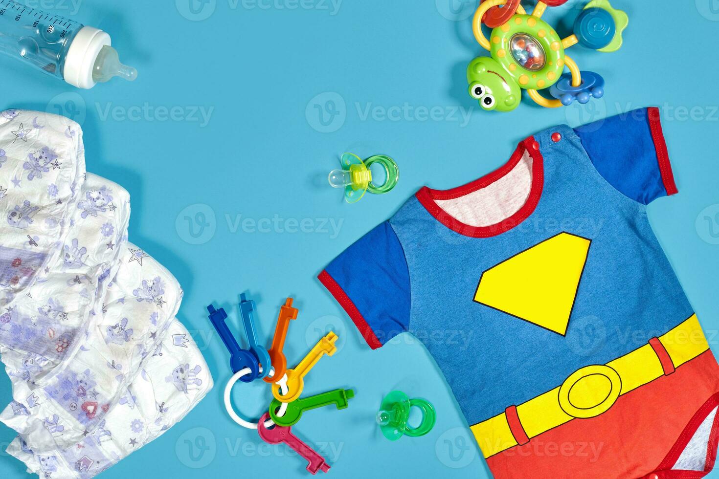 Baby clothing, toiletries, toys and health care accessories on blue background. photo