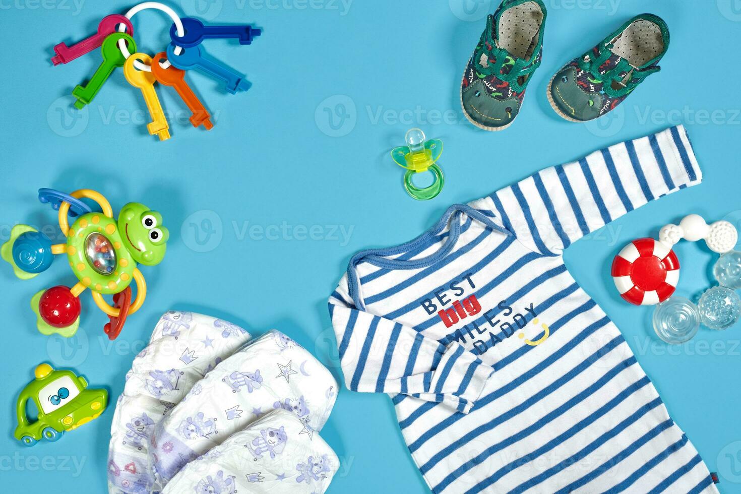 Baby clothing, toiletries, toys and health care accessories on blue background. photo