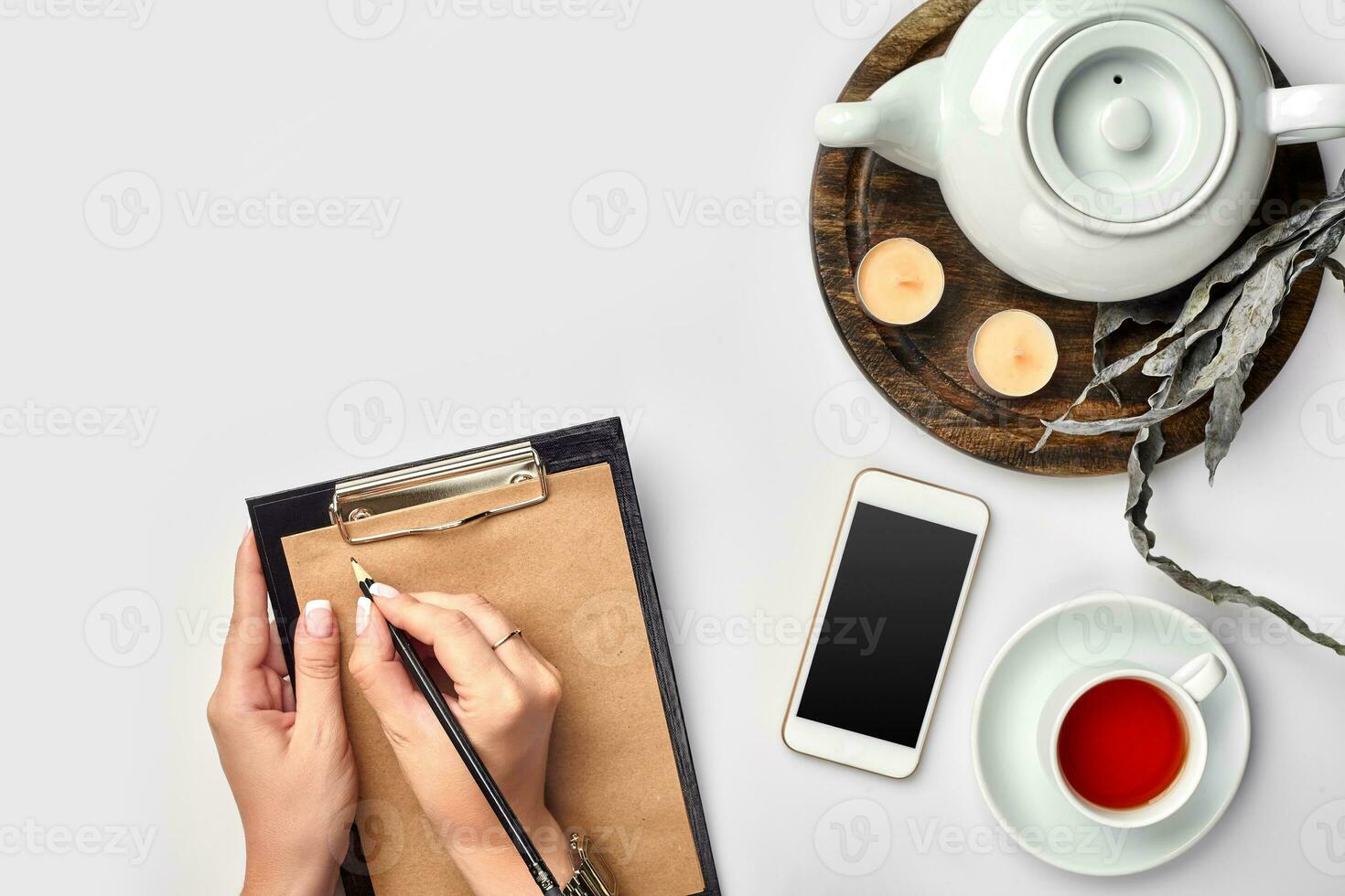 A woman hands writing on empty book note, diary, spread mockup, top view, studio. Cup of coffee break. photo