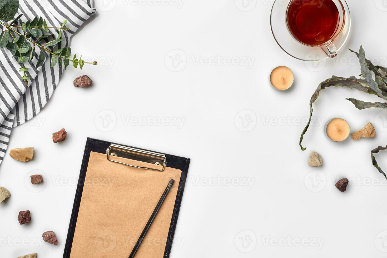 Blank opened notebook with cup of tea on white table. Top view. Writing concept photo