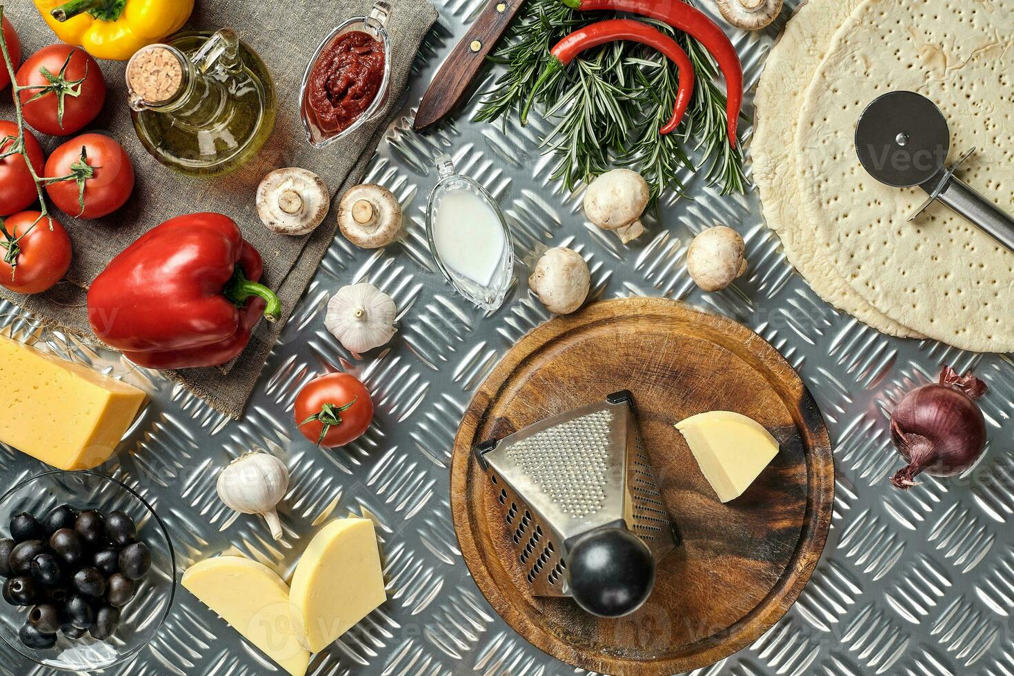 Cheese, different vegetables on metal table. Ingredients for traditional italian pizza. photo