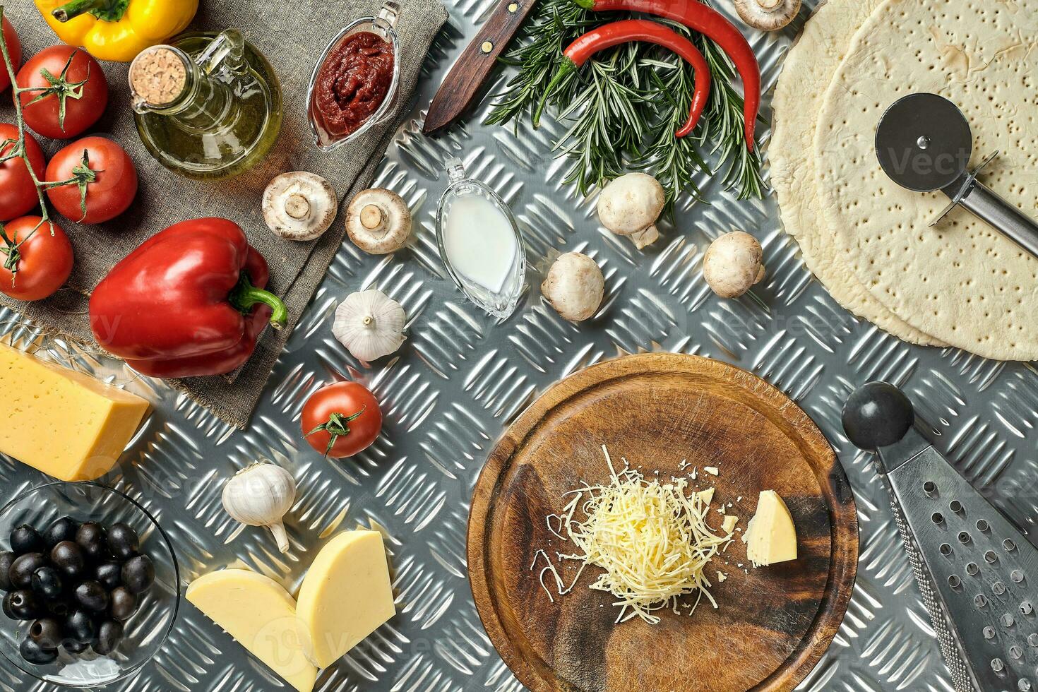 Cheese, different vegetables on metal table. Ingredients for traditional italian pizza. photo