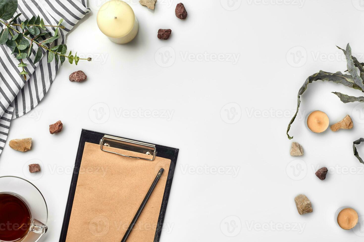Blank opened notebook with cup of tea on white table. Top view. Writing concept photo
