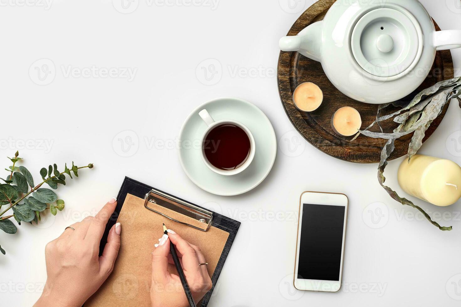 A woman hands writing on empty book note, diary, spread mockup, top view, studio. Cup of coffee break. photo