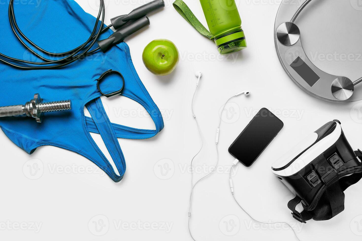 Sport, fitness, healthy lifestyle, cardio training and objects concept - close up of female sports clothing, skipping rope and bottle set photo