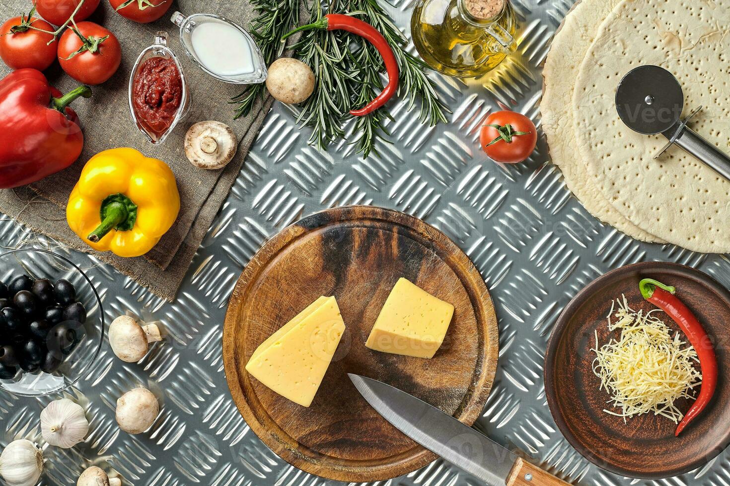 Cheese, different vegetables on metal table. Ingredients for traditional italian pizza. photo