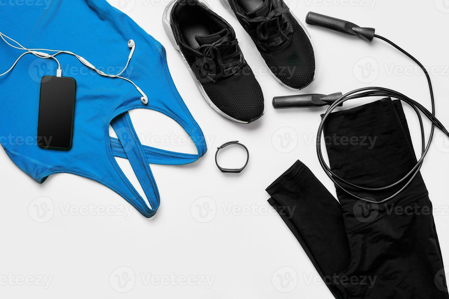 Sport, fitness, healthy lifestyle, cardio training and objects concept - close up of female sports clothing, skipping rope and bottle set photo