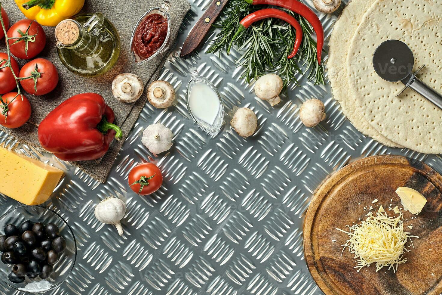Cheese, different vegetables on metal table. Ingredients for traditional italian pizza. photo