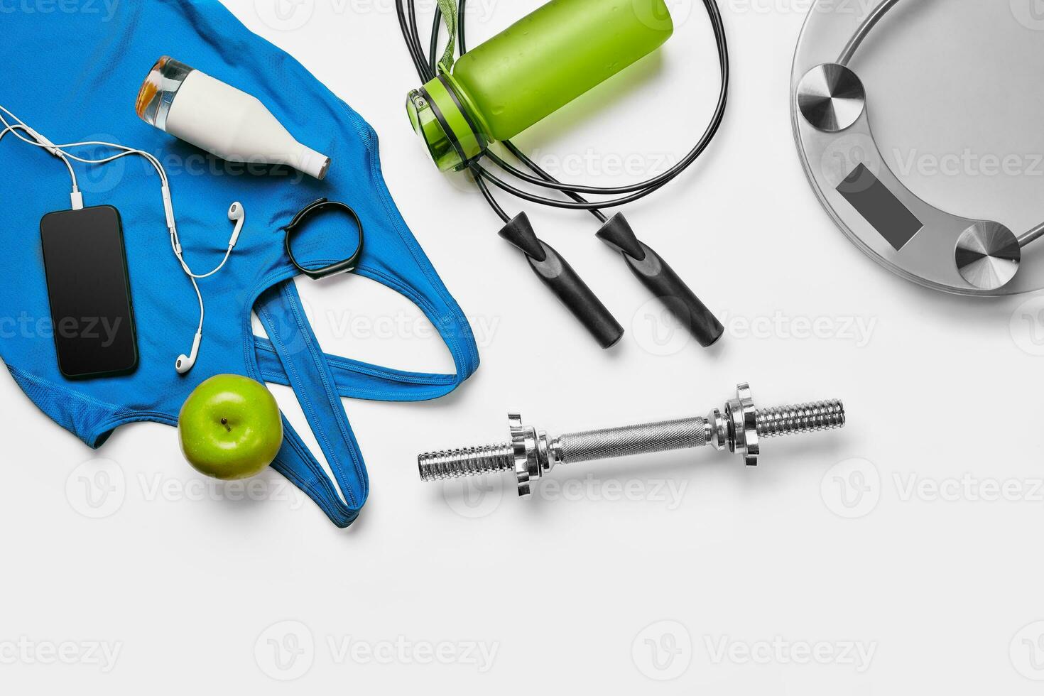 Sport, fitness, healthy lifestyle, cardio training and objects concept - close up of female sports clothing, skipping rope and bottle set photo