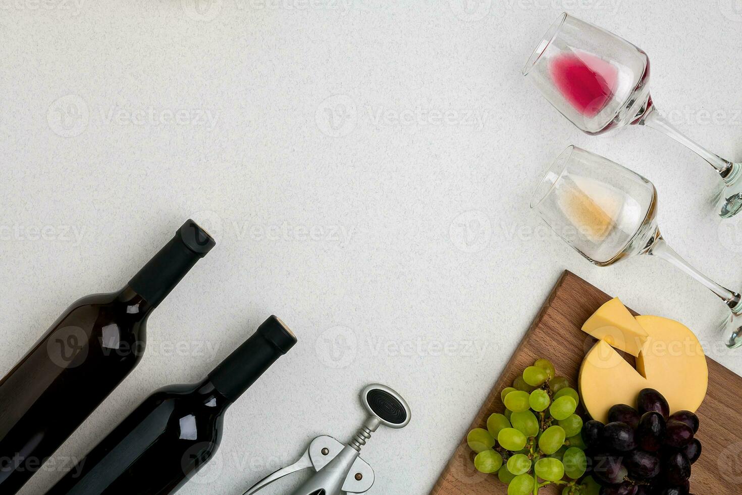 Two glasses of white and red wine, cheese and grapes. Top view photo