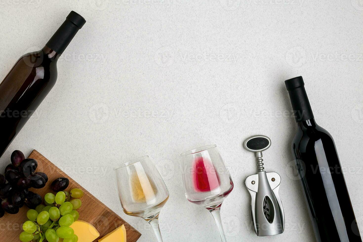 Glasses and bottles of red and white wine on white background from top view photo