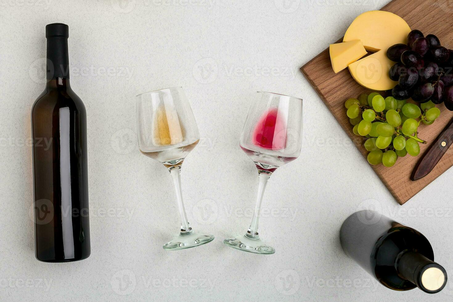 Two glasses of white and red wine, cheese and grapes. Top view photo