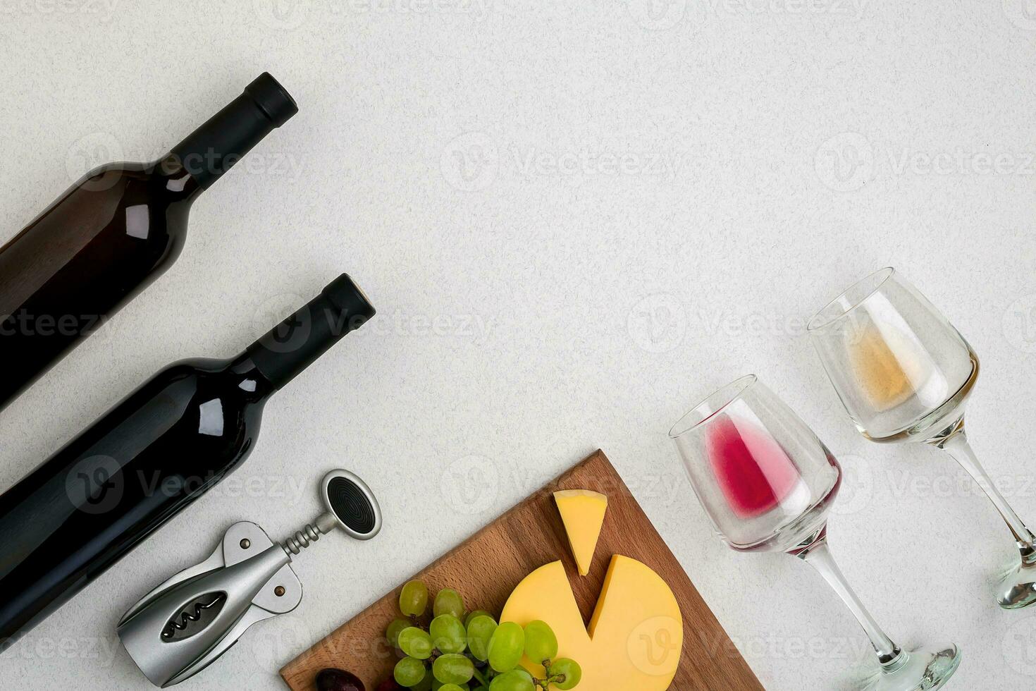 Two glasses of white and red wine, cheese and grapes. Top view photo