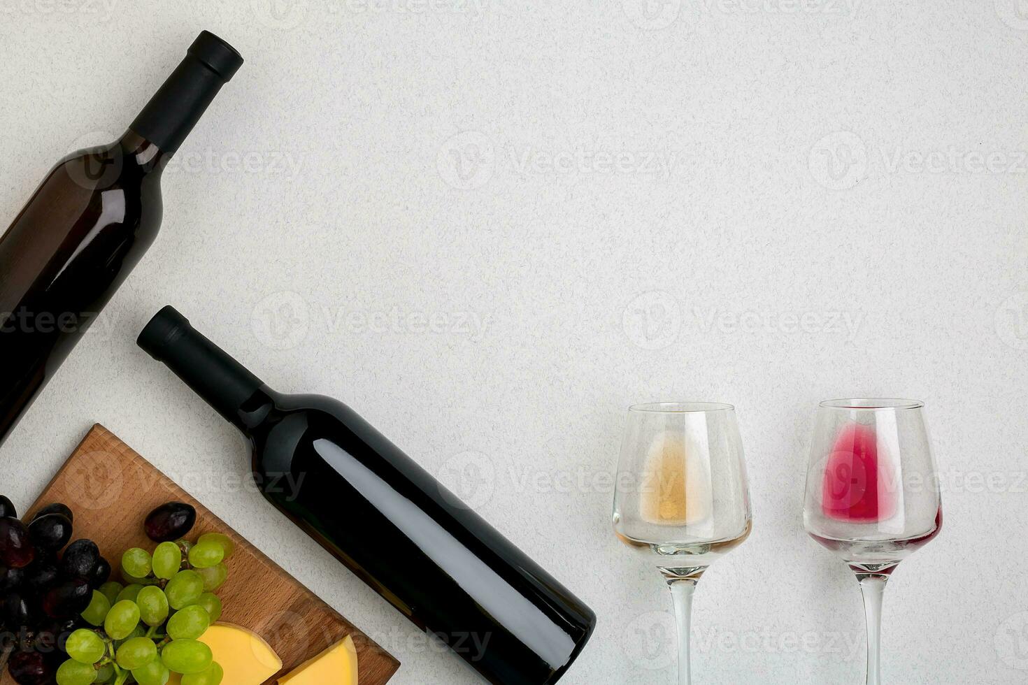 Two glasses of white and red wine, cheese and grapes. Top view photo