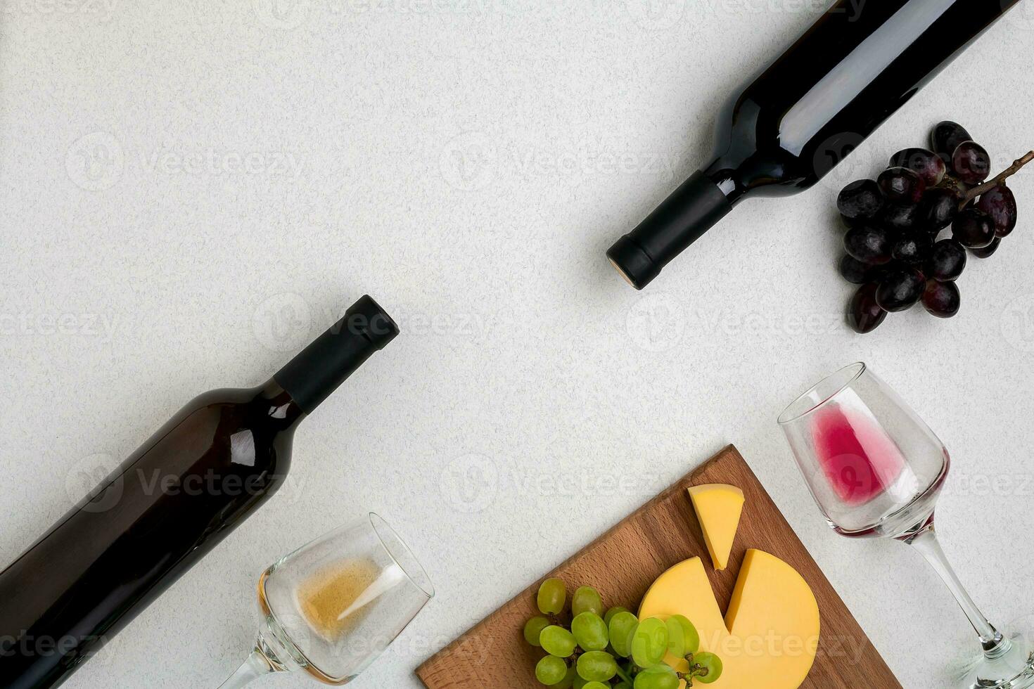 Two glasses of white and red wine, cheese and grapes. Top view photo