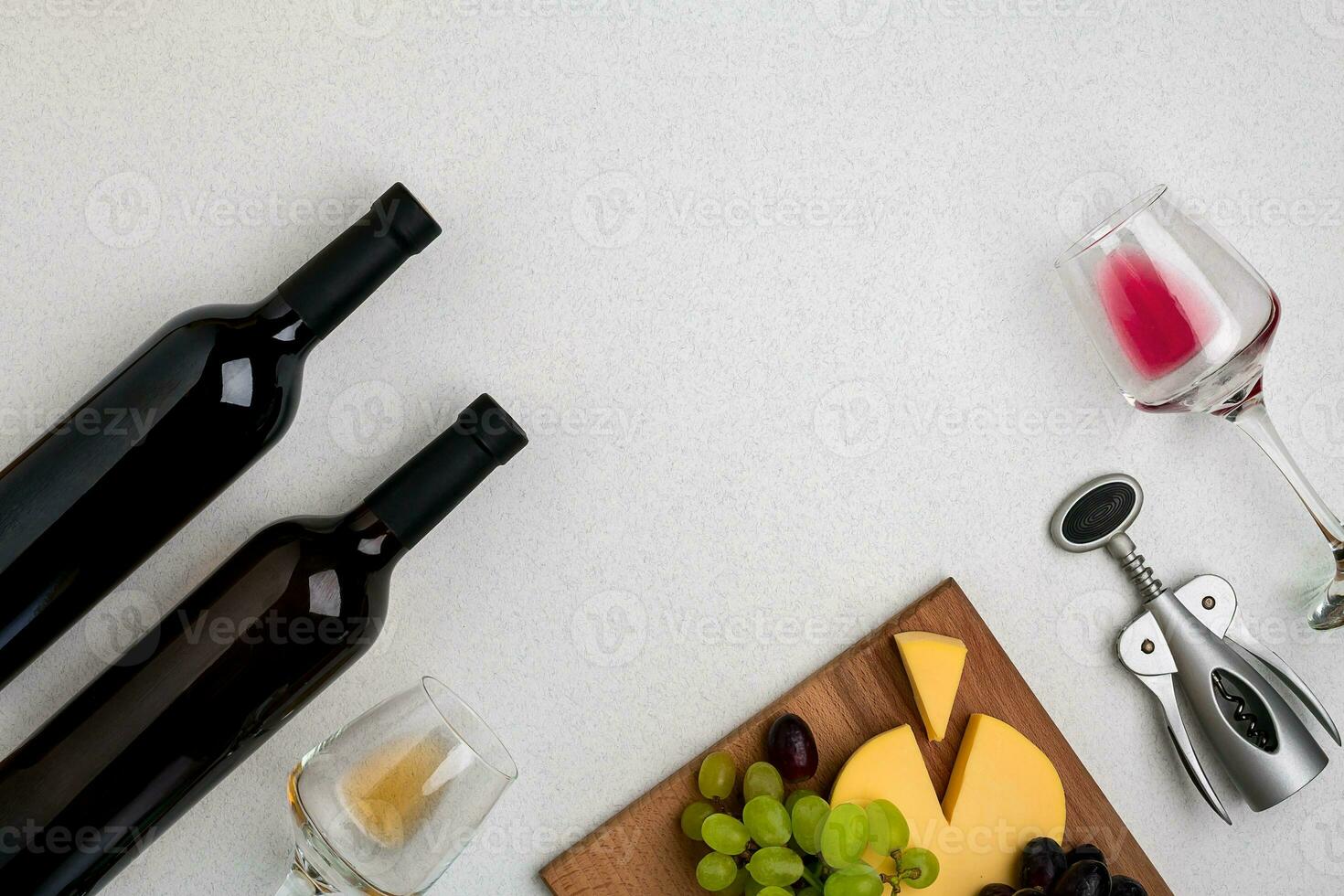 Two glasses of white and red wine, cheese and grapes. Top view photo