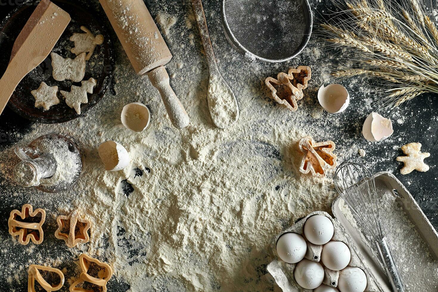 Cooking dough for cookies, butter, eggs, cooking equipment, flour on a black table. Top view with copy space, mockup for menu, recipe or culinary classes. Baking background. photo