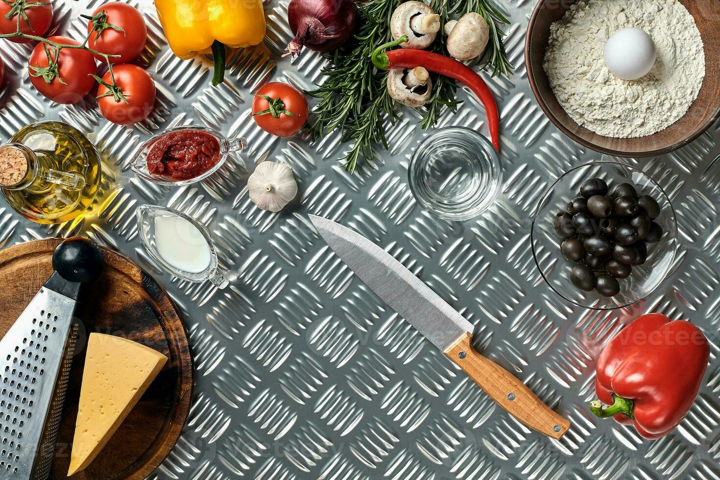 Food ingredients and spices for cooking pizza. Mushrooms, tomatoes, cheese, onion, oil, pepper, salt, egg, grater on metal background. Copy space. Top view photo